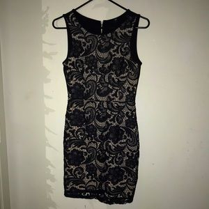 Nude background with a black floral pattern on top of it.